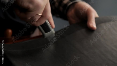 A master from a leather rudder cuts billets to make a belt. Procedure for the manufacture of leather belts. photo