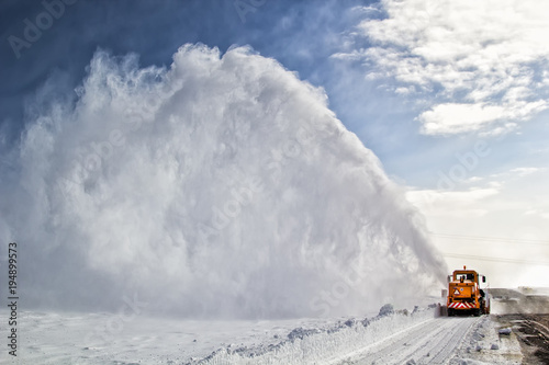 Snow-covered road cleaning by snow removal machine.