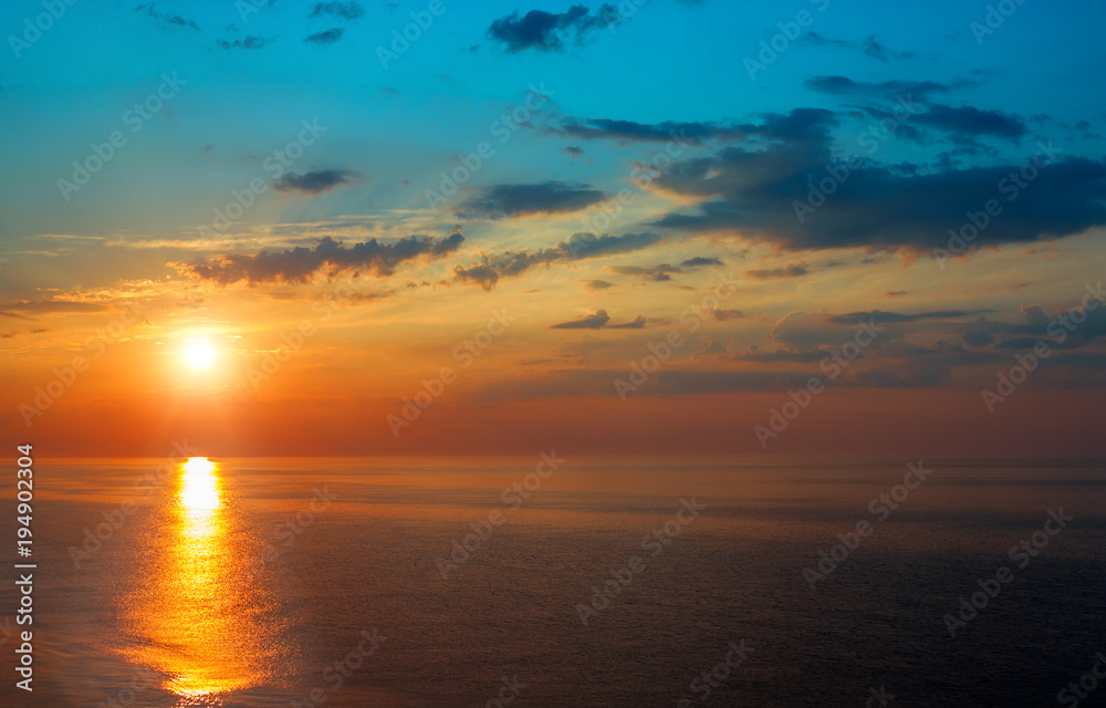 Obraz premium Beautiful sunrise over the quiet calm sea.