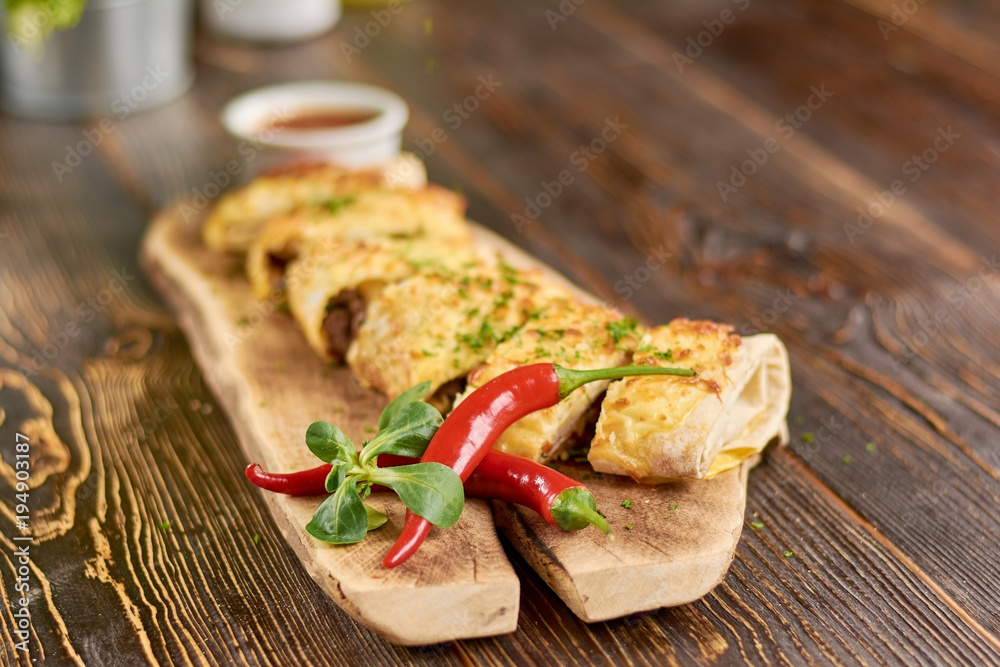 Mexican burrito served with chili pepper. Appetizing mexican burrito decorated with fresh basil and red chili pepper. Mexican burrito served with chili pepper. Appetizing mexican burrito decorated with fresh basil and red chili pepper.