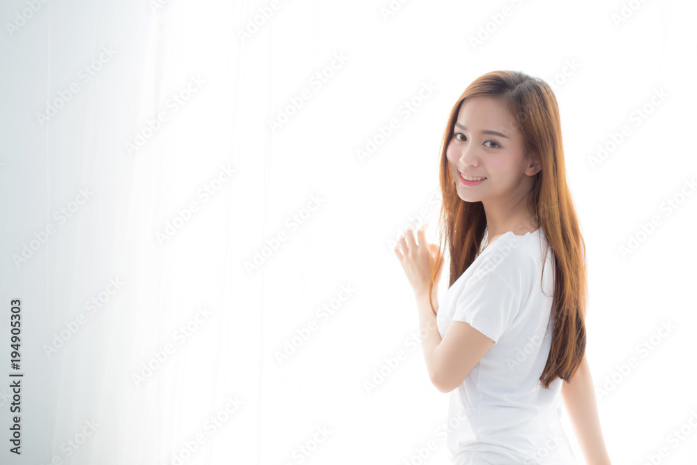 Beautiful young asian woman standing the window and smile while wake up with sunrise at morning, lifestyle and relax concept. Beautiful young asian woman standing the window and smile while wake up with sunrise at morning, lifestyle and relax concept.