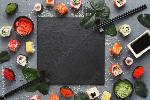 Square black slate with sushi on grey background