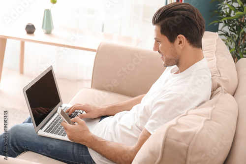 Young man relaxing on sofa ...