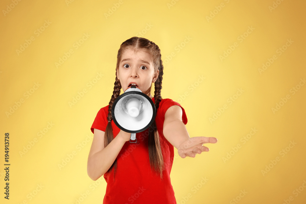 Obraz premium Emotional little girl with megaphone on color background