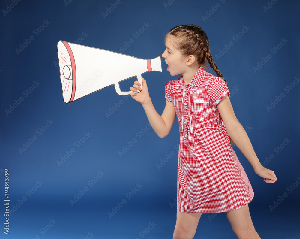 Little girl shouting into paper megaphone on color background Little girl shouting into paper megaphone on color background