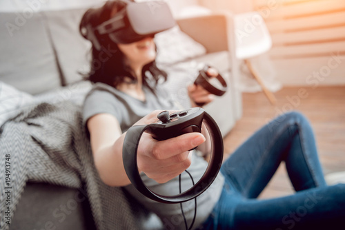 The beautiful girl playing games with virtual reality goggles