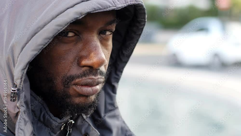 Sad Hodded black migrant looking at camera - outdoor Sad Hodded black migrant looking at camera - outdoor
