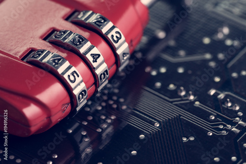 Code numbers on combination pad lock on computer circuit board with solder, digital cyber safety or security encryption concept, technology to encode online information or data protection