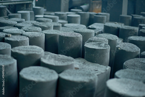 Graphite manufactured articles with unequal height standing at production department of modern plant, close-up shot photo