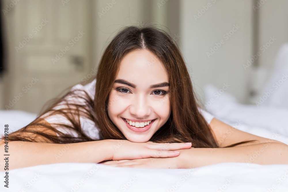 Charming woman smile face close up and she lying on the bed in the morning