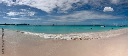 Fototapeta Naklejka Na Ścianę i Meble -  Panorama of a beautiful sunny day at Bayshore / Pebbles Beach (Carlisle Bay) near Bridgetown Barbados (Caribbean Island) - white sand, waves, blue sky with white clouds & sunshine