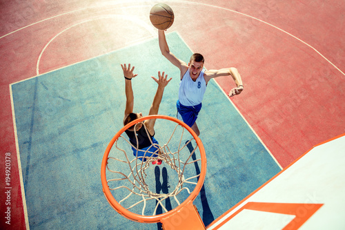 High angle view of basketball player dunking basketball in hoop © FS-Stock