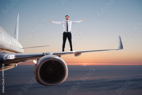Businessman over an airplane swing. Concept of freedom
