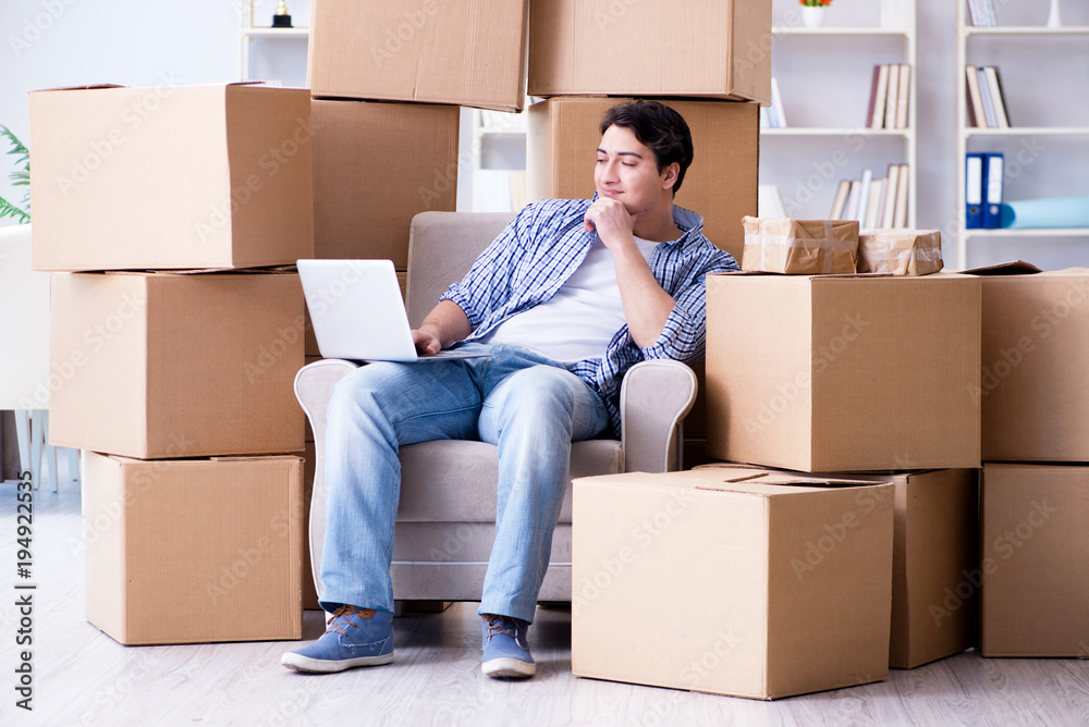 Young man moving in to new house with boxes Young man moving in to new house with boxes