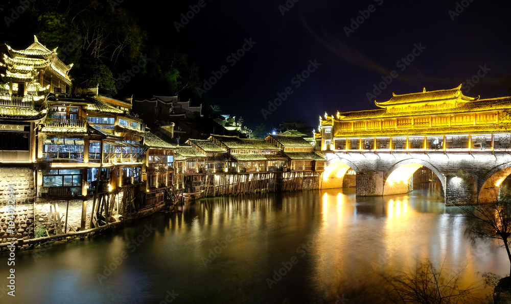 Fenghuang, phoenix ancient town, night view with reflections of the town on the river