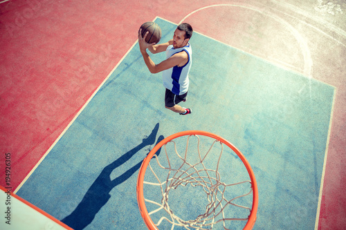 High angle view of basketball player dunking basketball in hoop photo