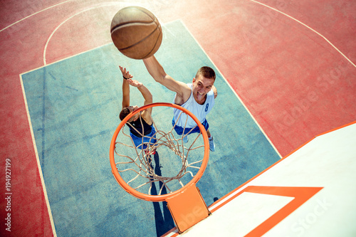 High angle view of basketball player dunking basketball in hoop photo