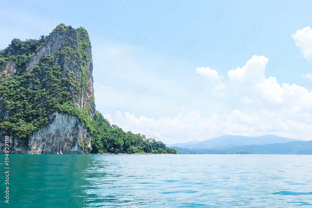 The limestone mountains are surrounded by crystal clear water in dam of southern Thailand.