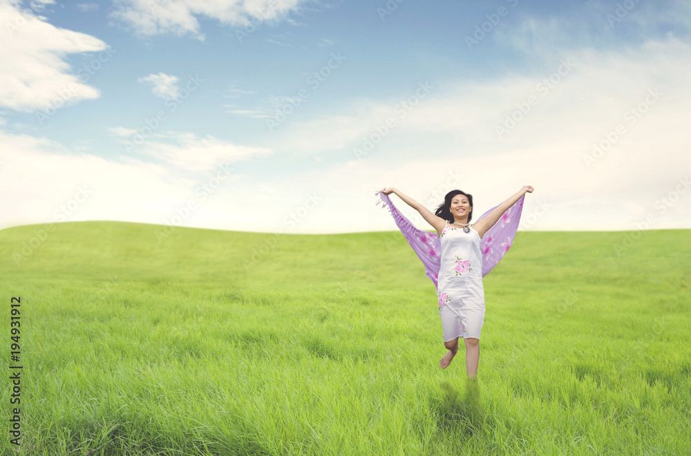 Beautiful asian woman running on green field Beautiful asian woman running on green field