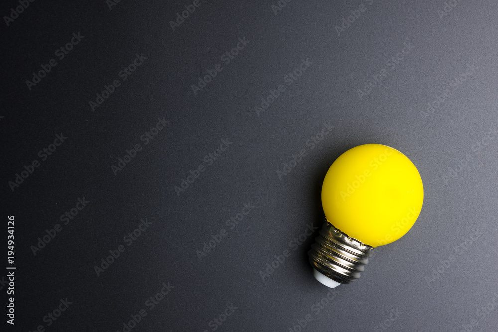 Yellow light bulb on black background with copy space. Yellow light bulb on black background with copy space.