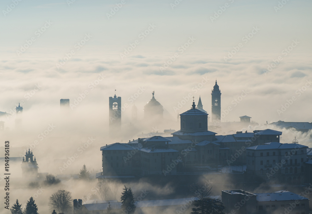 Bergamo, Italy. Drone aerial view of an amazing landscape of the fog rises from the plains and covers the old town