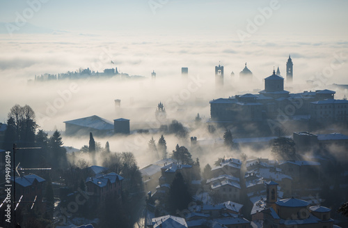 Bergamo  Italy. Drone aerial view of an amazing landscape of the fog rises from the plains and covers the old town