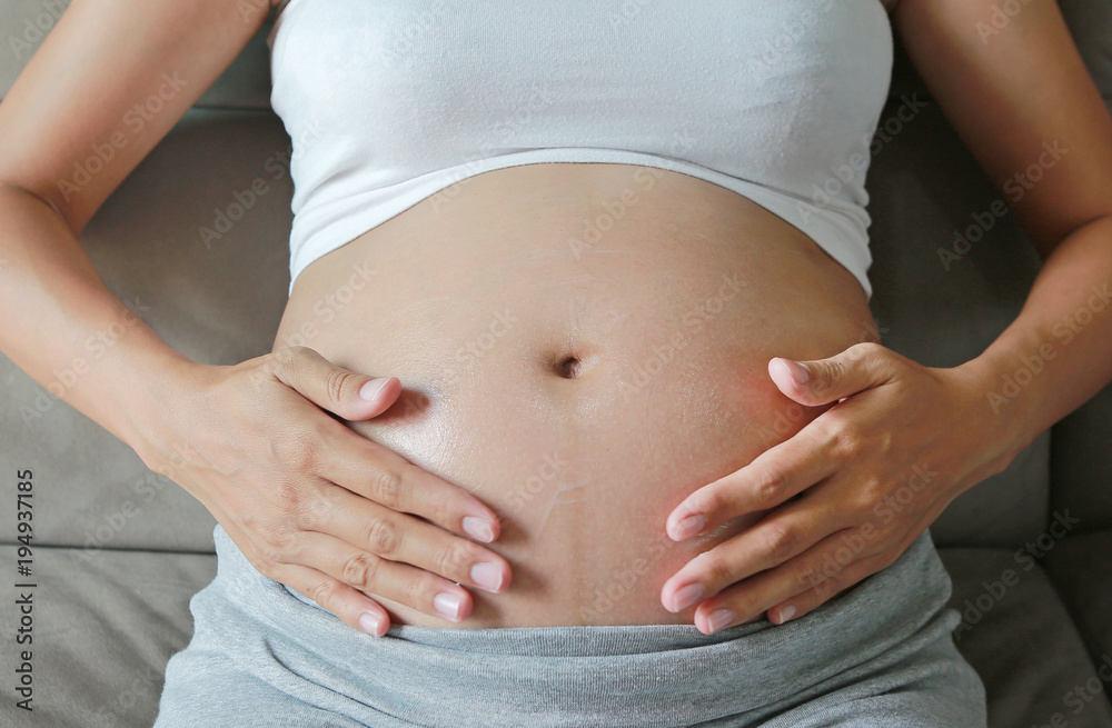 Pregnant Woman applying stretch marks cream on her belly. Pregnant Woman applying stretch marks cream on her belly.