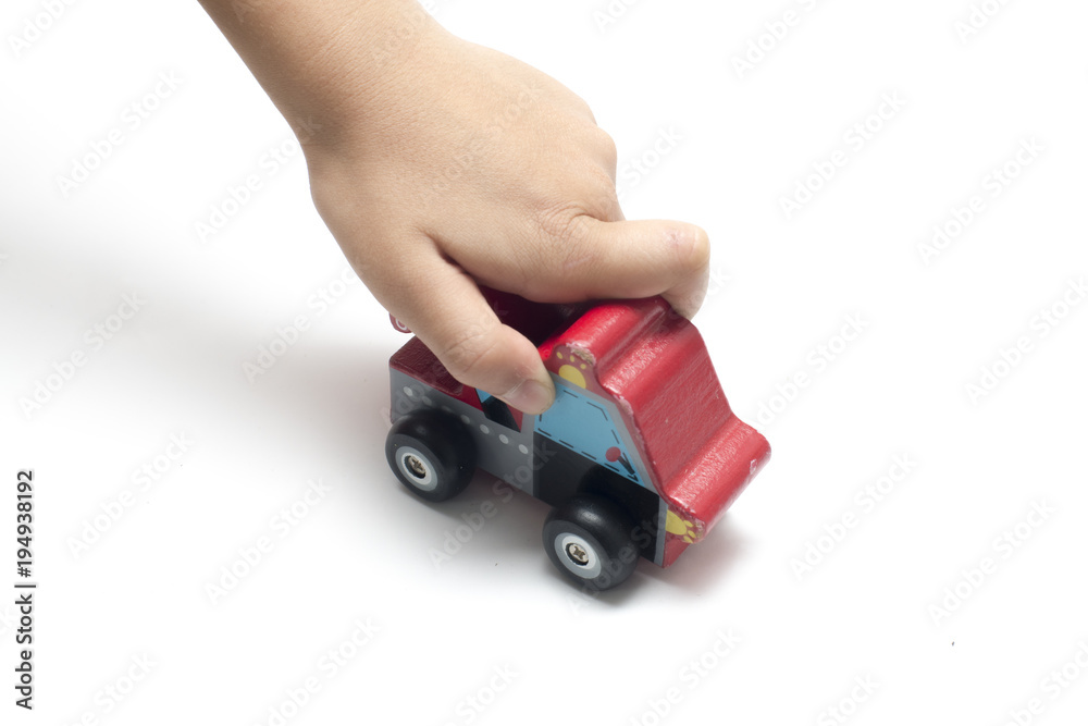 child playing a wooden toy car.