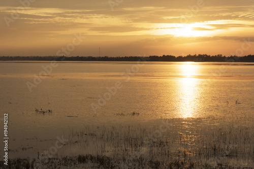 Silhouette woman holding air balloons standing and see the lake on the sunset