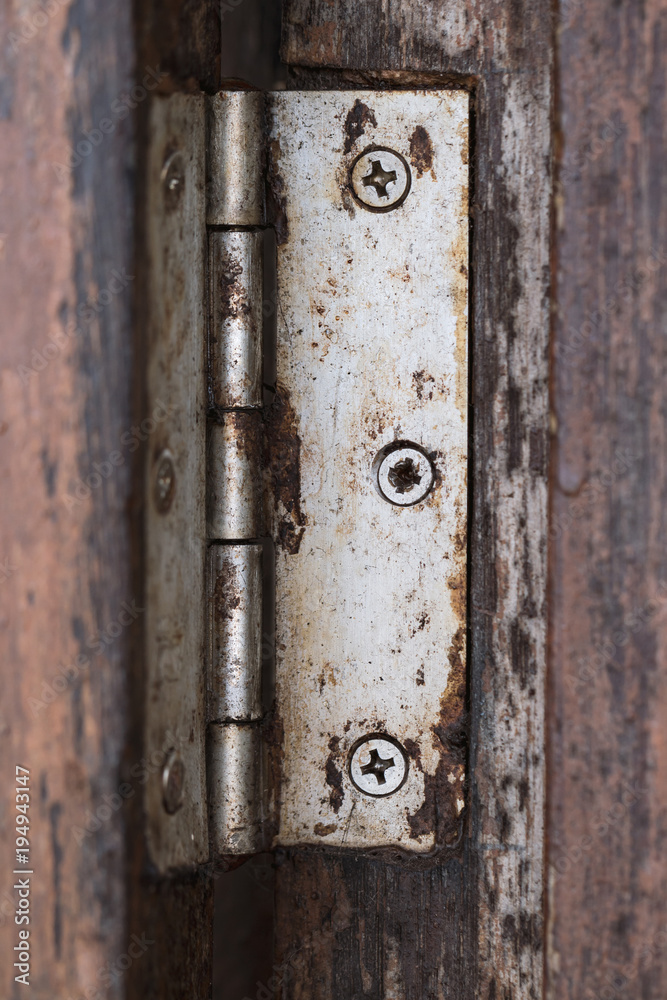 old hinge on wooden door or window, shallow depth of field