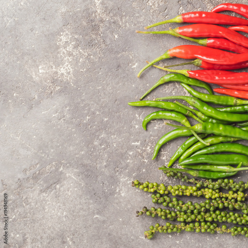  Different kinds of hot pepper red green black peas on a gray concrete background. photo