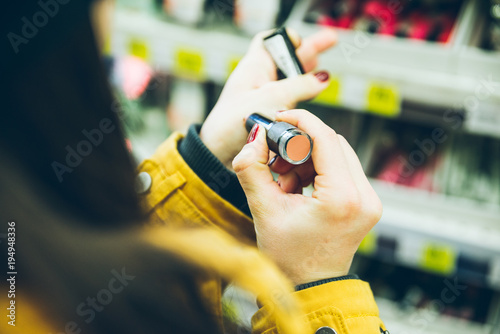 woman choose lipstick in store close up