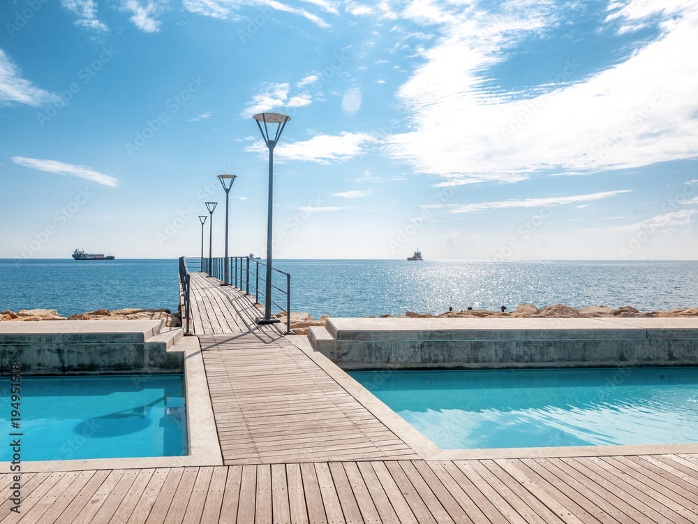 Obraz premium Island of Cyprus, Limassol. Beautiful embankment on a sunny day, wooden pier for walks