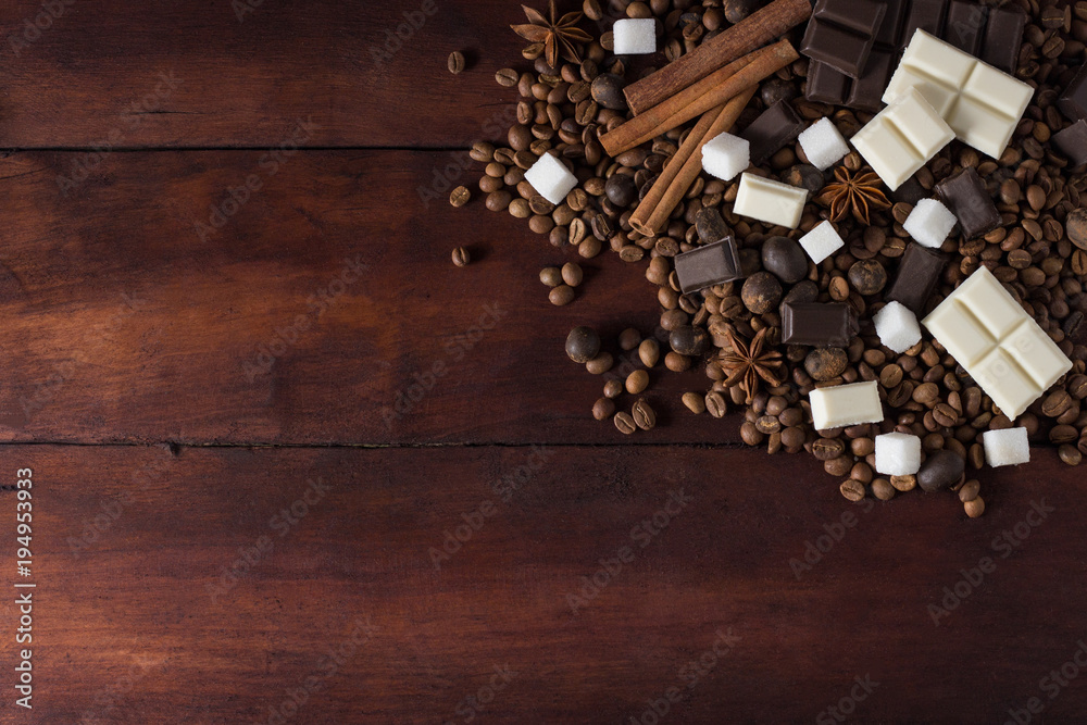 Dark and White Chocolate, Coffee Beans, Chocolate Balls, Spices, Cinnamon on the Old Wooden Table. Flat lay, top view Dark and White Chocolate, Coffee Beans, Chocolate Balls, Spices, Cinnamon on the Old Wooden Table. Flat lay, top view