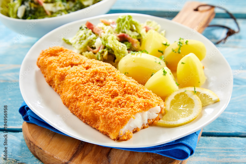 Piece of crispy breaded fish with potatoes Piece of crispy breaded fish with potatoes
