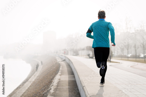 Determined sportsman fitness exercising by jogging outdoor