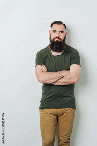 Bearded man standing by bright wall