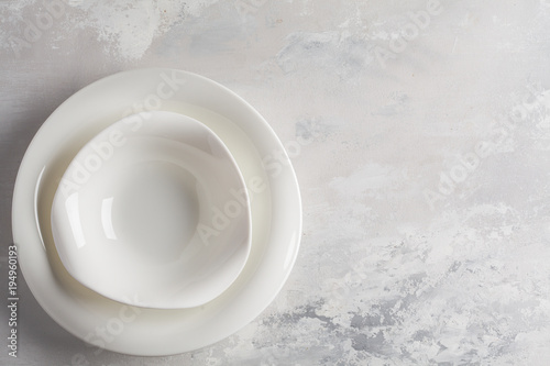 Beautiful vintage white empty plates on a gray background. Copy space  top view. Table setting background concept.