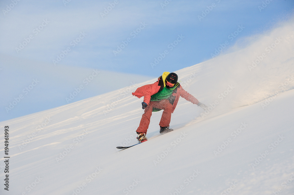 Active snowboarder riding on the snowy slope