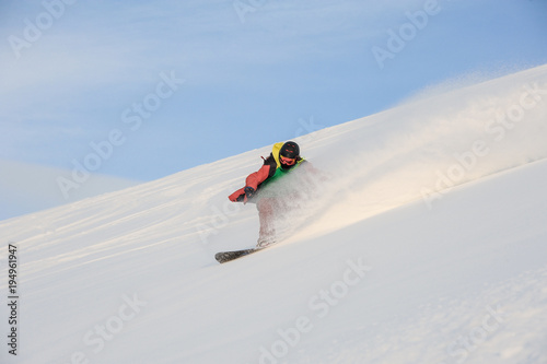 Professional snowboarder riding down the snowy slope
