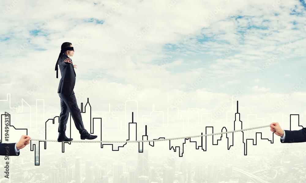 Business concept of risk support and assistance with man balancing on rope Business concept of risk support and assistance with man balancing on rope