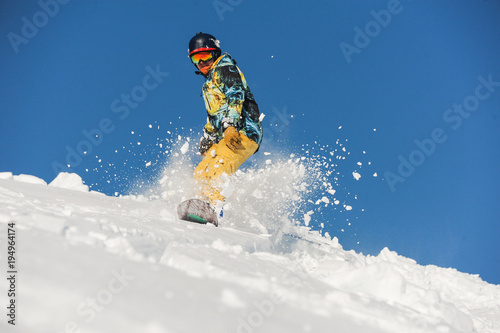 Bottom view of freeride snowboarder sliding down the slope