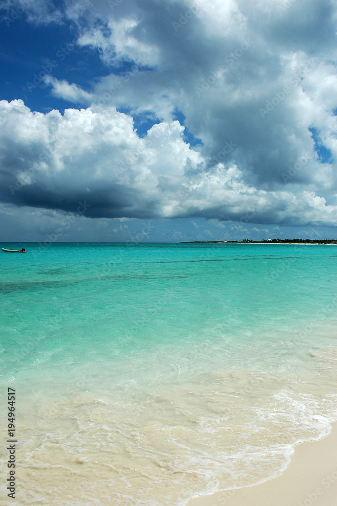 Horizontal view of tropical turquoise Caribbean sea, white sand, and heavy stormy clouds. Copy space, tranquil atmosphere of a popular vacation destination, holiday paradise, secret beach Horizontal view of tropical turquoise Caribbean sea, white sand, and heavy stormy clouds. Copy space, tranquil atmosphere of a popular vacation destination, holiday paradise, secret beach