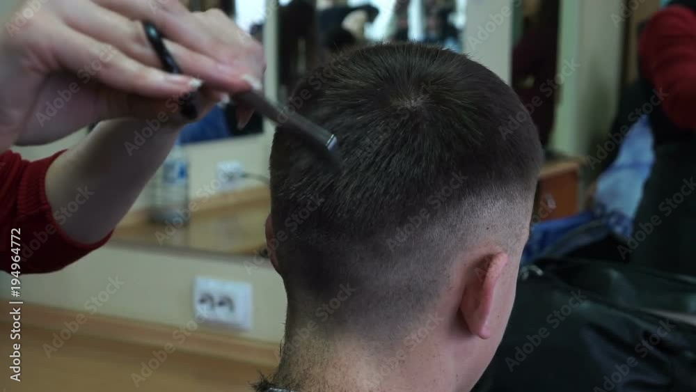 Barber cuts the hair of the client with scissors, close up. Barber cuts the hair of the client with scissors, close up.