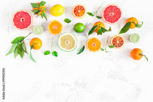 Fruit border. Colorful fresh fruits on white table. Orange, tangerine, lime, lemon, grapefruit. Flat lay, top view, copy space