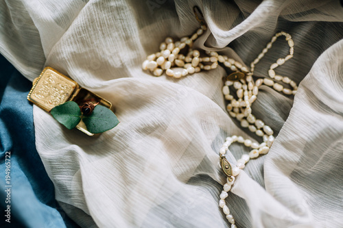Antique beads and a ring in a gold box on a fine fabric