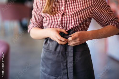 Mid section of waitress wearing apron at cafe