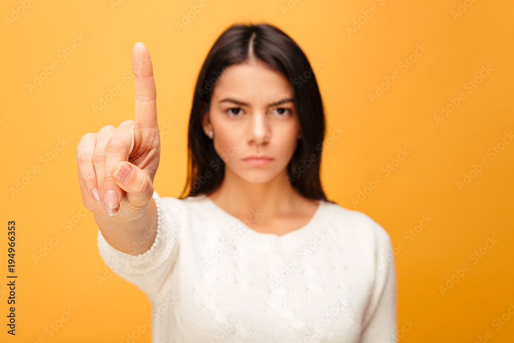 Portrait of a serious young woman showing stop gesture