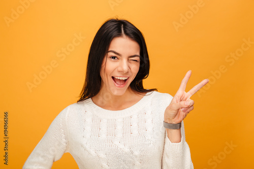 Portrait of a happy young woman showing victory sign
