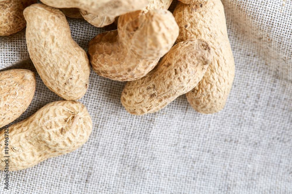 Heap of peanuts on light tablecloth, close-up, shallow depth of field, selective focus, macro Heap of peanuts on light tablecloth, close-up, shallow depth of field, selective focus, macro